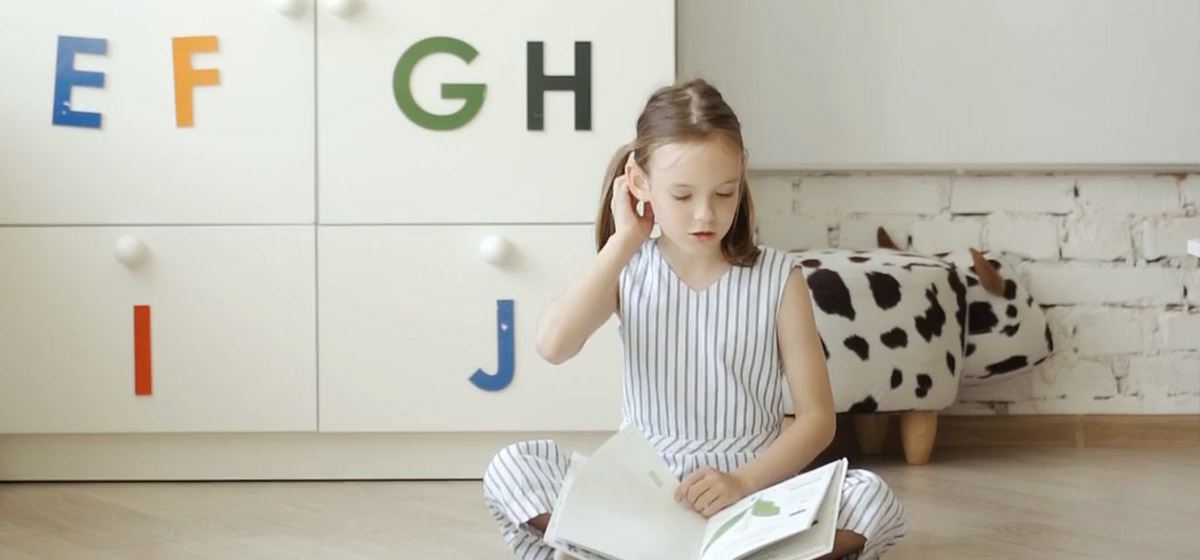 Mädchen beim Englisch Lernen mit einem Buch in der Hand