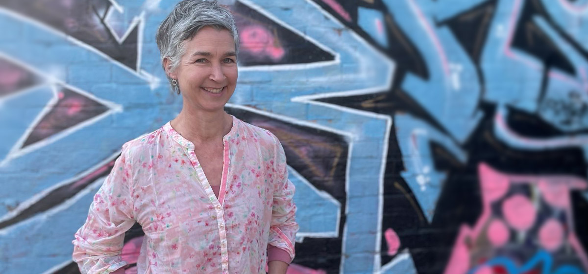 Vivian Glas - zertifizierte LRS Deutschland Trainer steht vor einer Wand einem blauen Graffitibild